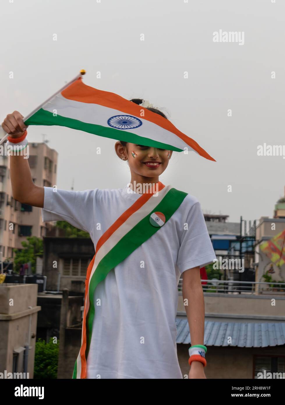 Süßes indisches Mädchen, das indische Flagge schwenkt, den Indischen Unabhängigkeitstag feiert und Patriotismus zeigt. Selektiver Fokus auf Flagge Stockfoto
