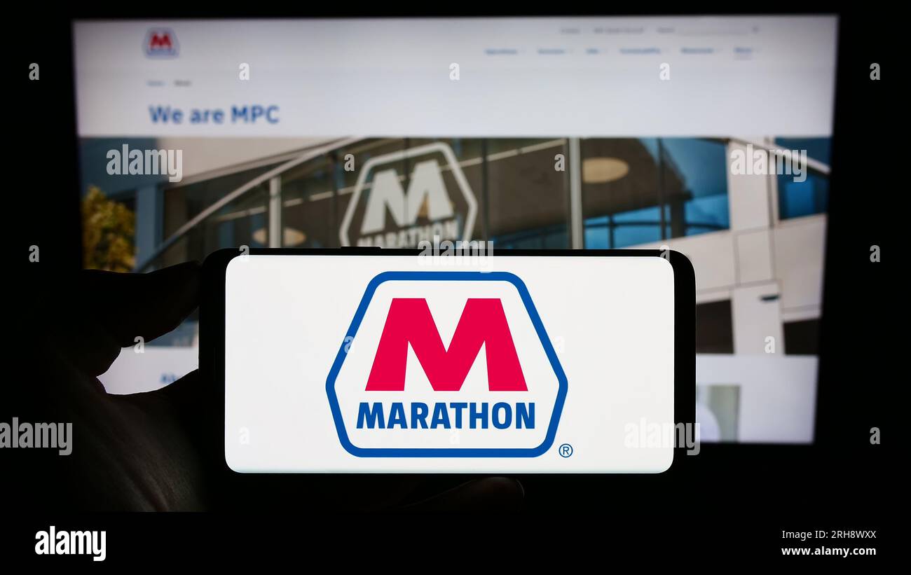 Person, die ein Handy mit dem Logo des amerikanischen Ölkonzerns Marathon Petroleum Corporation auf dem Bildschirm vor der Webseite hält. Konzentrieren Sie sich auf das Display des Telefons. Stockfoto