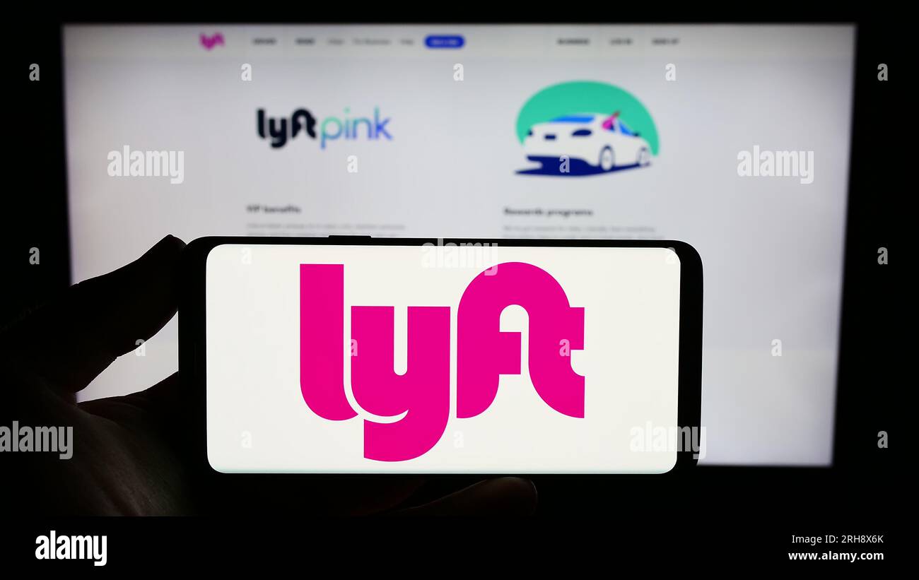 Person, die ein Smartphone mit dem Logo des US-Mobilitätsunternehmens Lyft Inc. Auf dem Bildschirm vor der Website hält. Konzentrieren Sie sich auf das Display des Telefons. Stockfoto