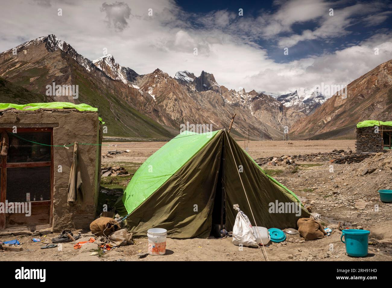 Indien, Ladakh, Zanskar, Rangdum, Straßenarbeiter-Zelt mit schneebedeckten Bergen dahinter Stockfoto