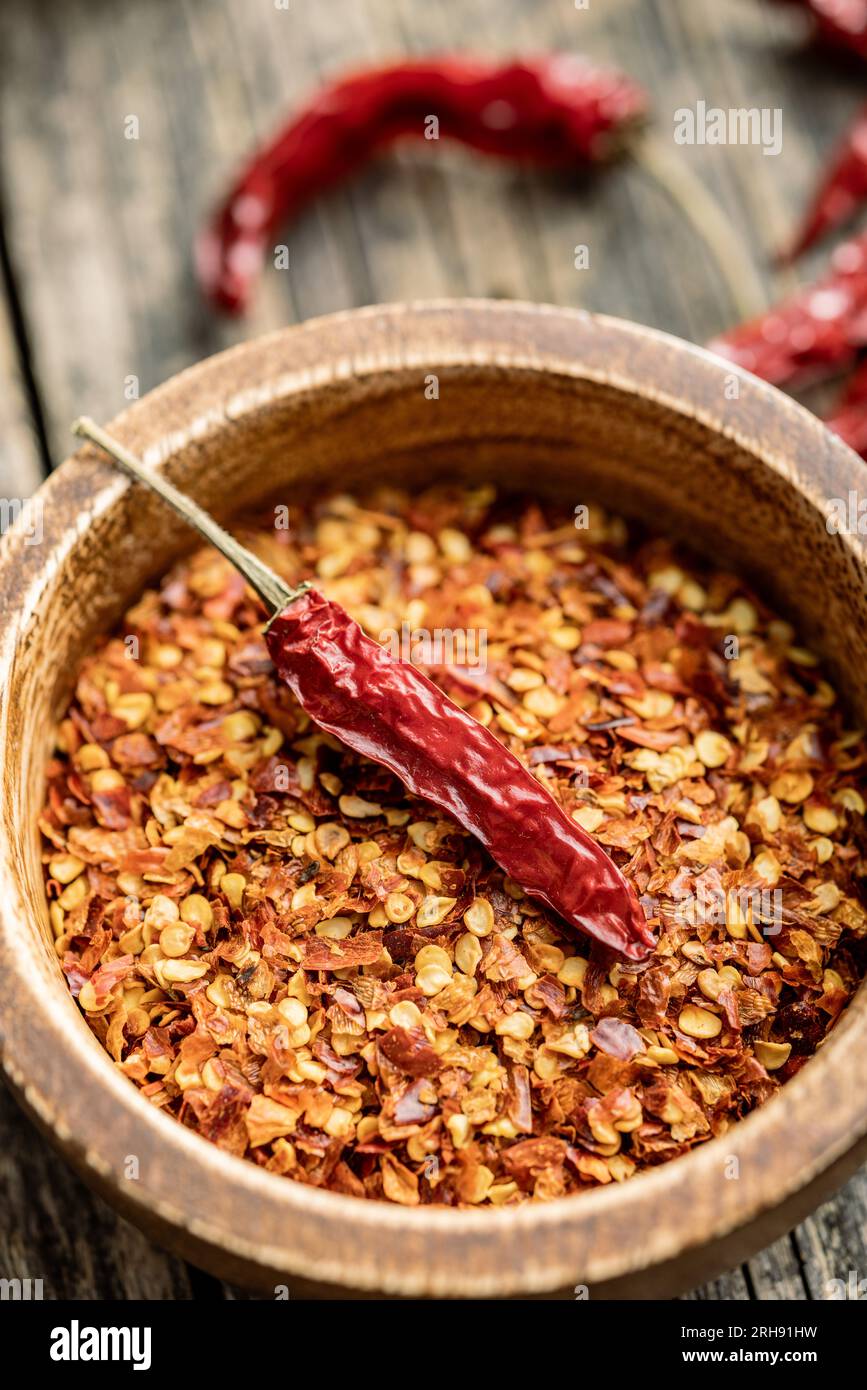 Zerdrückte und ganze Chili-Paprika in der Schüssel. Stockfoto