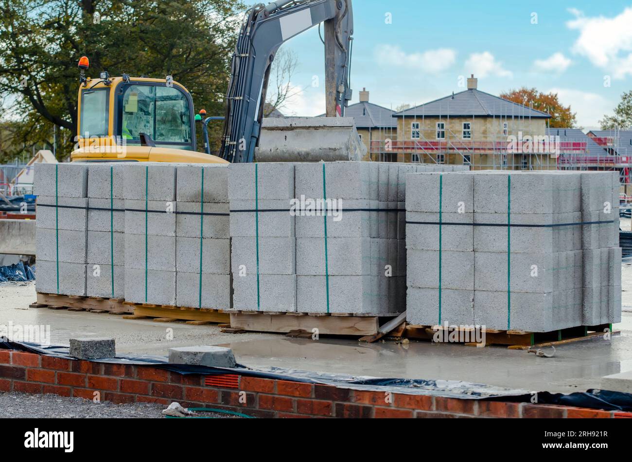 Betonblöcke werden an die Baustelle geliefert und neben dem Arbeitsplatz platziert und sind bereit für Mauerwerk Stockfoto