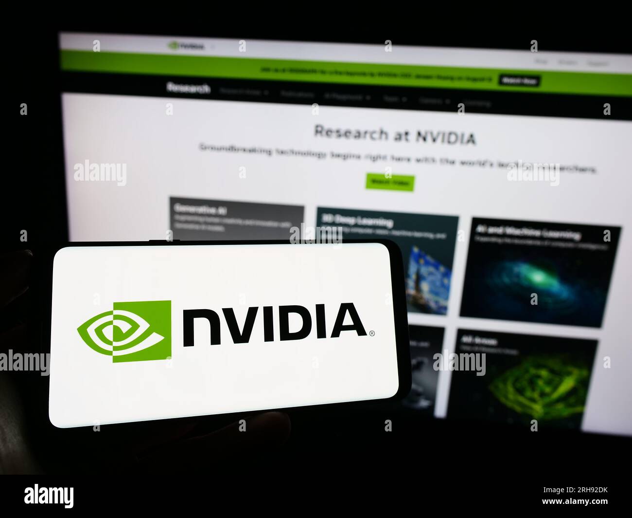 Person, die ein Mobiltelefon mit dem Logo des US-Technologieunternehmens Nvidia Corporation auf dem Bildschirm vor der Unternehmenswebseite hält. Konzentrieren Sie sich auf das Display des Telefons. Stockfoto