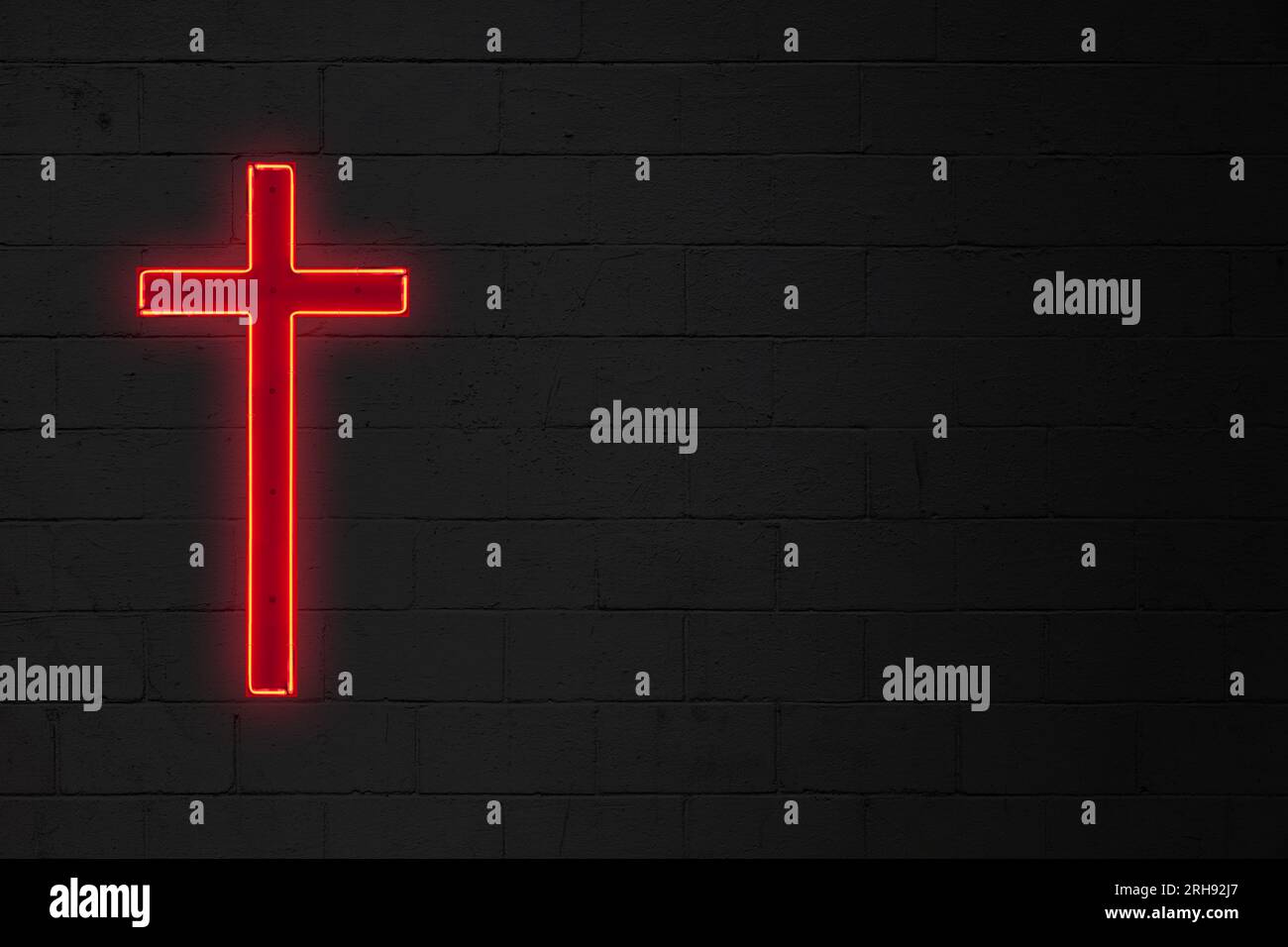 Neonlicht in Form eines roten christlichen Kreuzes, das an einer Ziegelwand befestigt ist. Stockfoto