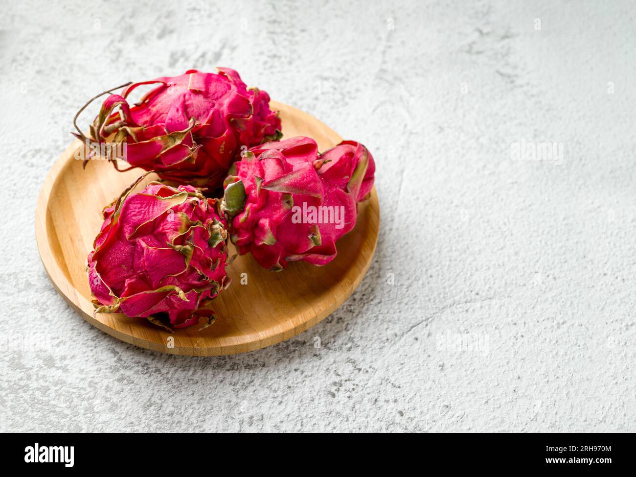 Reife rote Drachenfrucht auf einem Steintisch Stockfoto