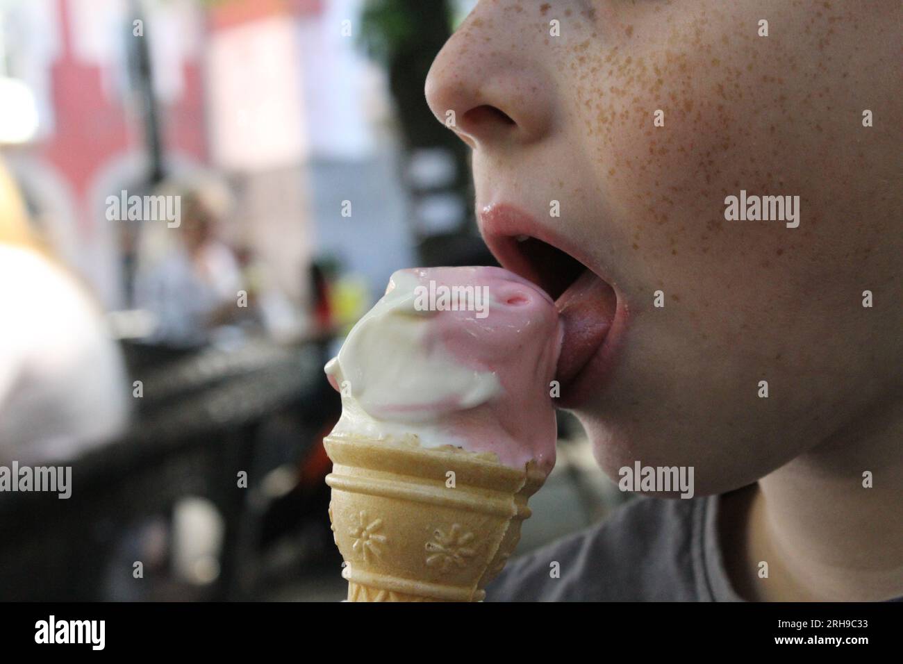 Der Sommersprossen-Junge isst Eis Stockfoto