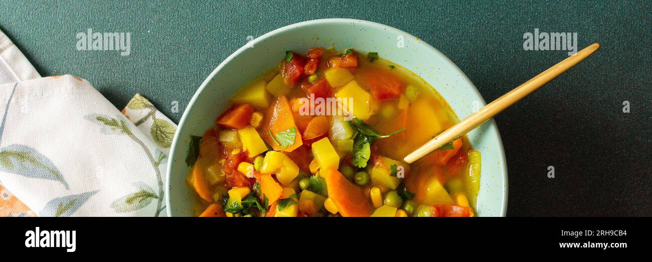 Minestronsuppe aus Zucchini und Tomaten, Zwiebeln und Karotten, Mais und Erbsen mit Petersilie, eine Suppe aus der Nähe, vegetarisches Suppenbanner Stockfoto