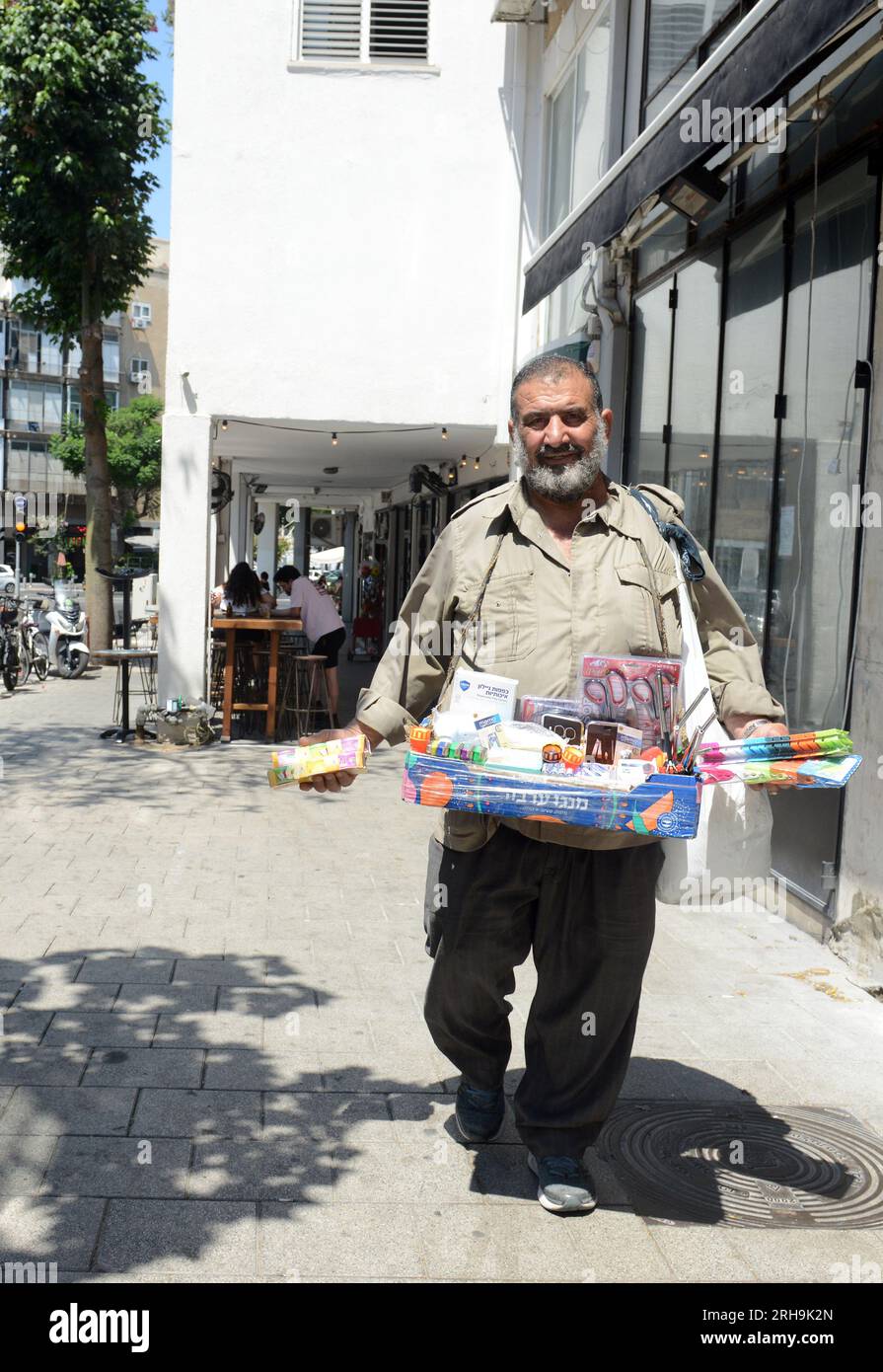 Ein Mann, der auf der King George V Street spaziert und in Cafés und Restaurants Sachen an Kunden verkauft. Tel-Aviv, Israel. Stockfoto