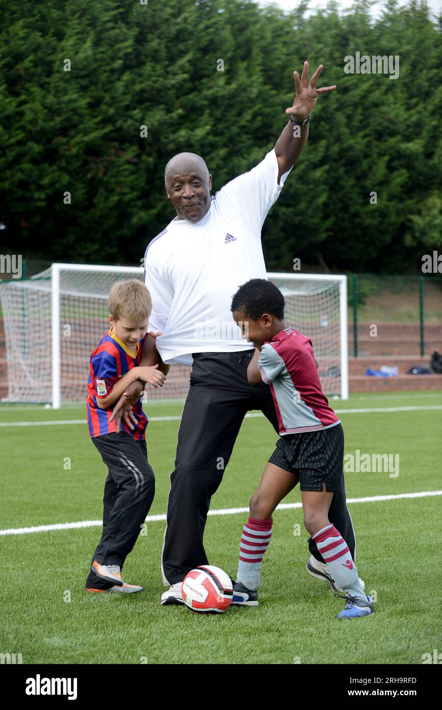 Der ehemalige Fußballspieler Garry Thompson testete das neue 3G-Spielfeld mit einheimischen Kindern in Smethwick in den West Midlands. Stockfoto