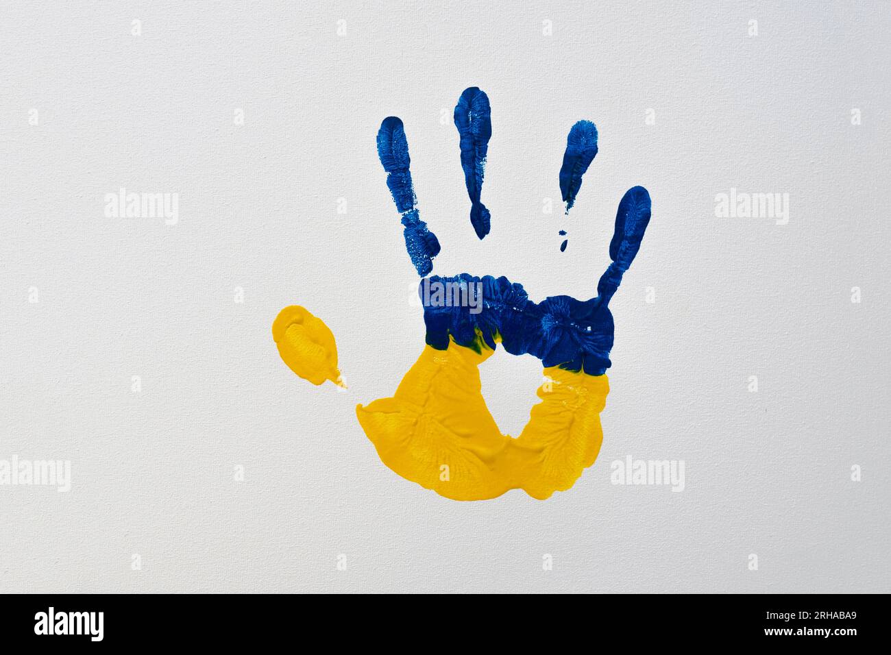 Gelbblauer Handflächendruck auf weißer Leinwand (Nahaufnahme). Nationale Symbole der Ukraine Stockfoto