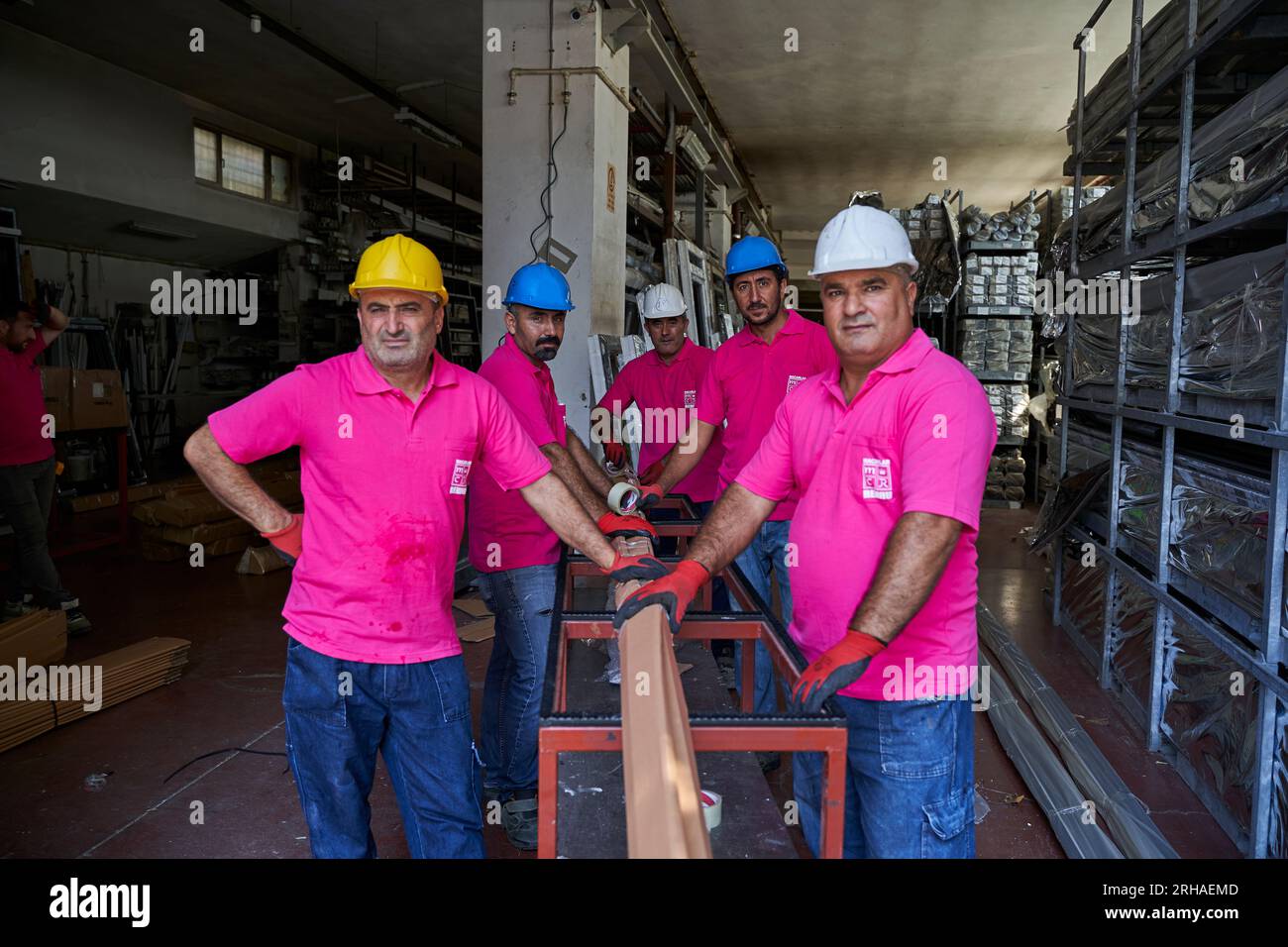 Arbeiter, die Kartonkartons für den Versand im Lager verpacken. Ein Bediener schließt einen Karton mit Klebeband in einem Lager. Stockfoto