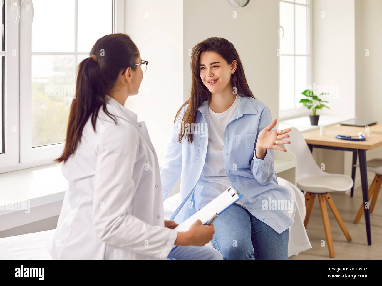 Arzthalter mit Termin und Zuhören ihrer Patientin in der Klinik. Stockfoto