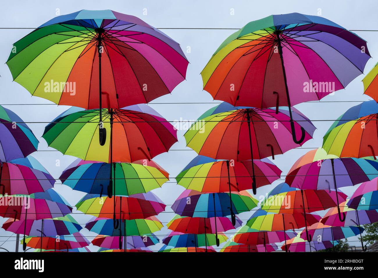 Viele regenbogenfarbene Regenschirme am Himmel Stockfoto