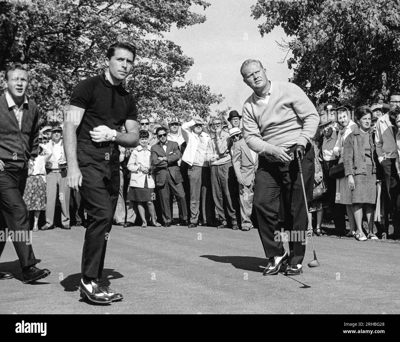 Akron, Ohio 1965 Arnold Palmer (L) und Gary Player (C), folgen Sie dem Flug von Jack Nicklaus' Abschlag im Firestone Country Club. Stockfoto