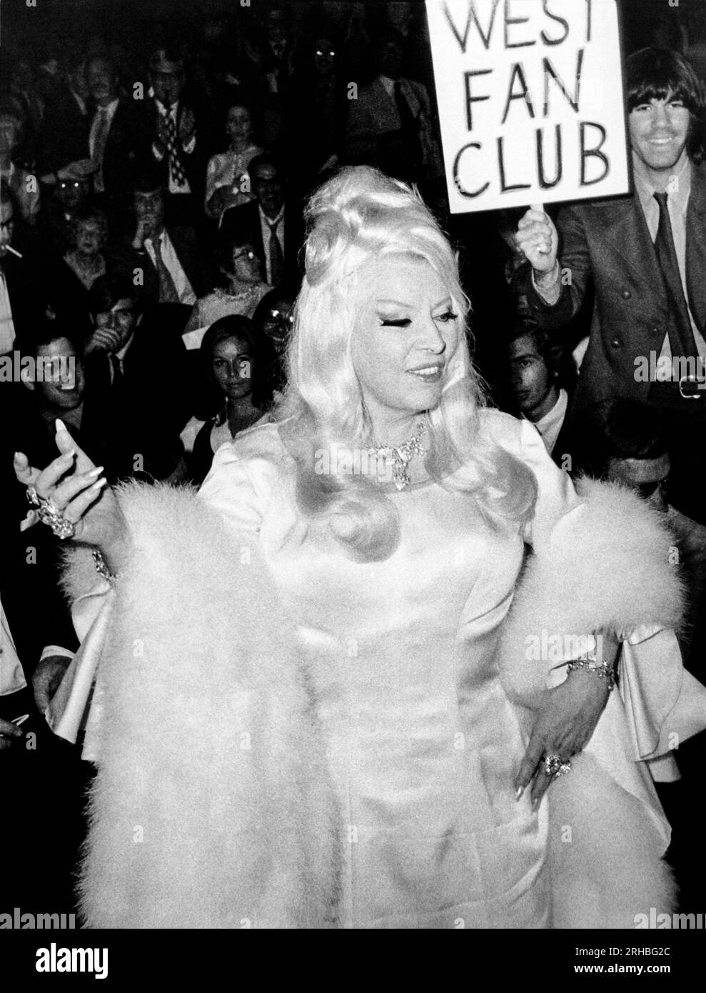 New York, New York: 23. Juni 1970 die Schauspielerin Mae West begrüßt die Menge von 10.000 Fans, die sich versammelten, um sie zu sehen, als sie an der Premiere des Films „Myra Breckinridge“ im Criteria Theater teilnahm. Stockfoto