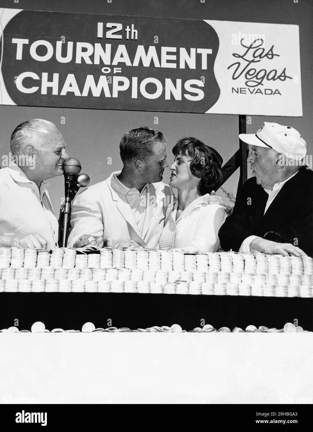 Las Vegas, Nevada: 1963 professioneller Golfer Jack Nicklaus küsst seine Frau, nachdem er das Turnier der Champions im Desert Inn Country Club gewonnen hat. Der Besitzer des Desert Inn Wilbur Clark (L) und der Journalist Walter Winchell (R) sind Zuschauer. Stockfoto