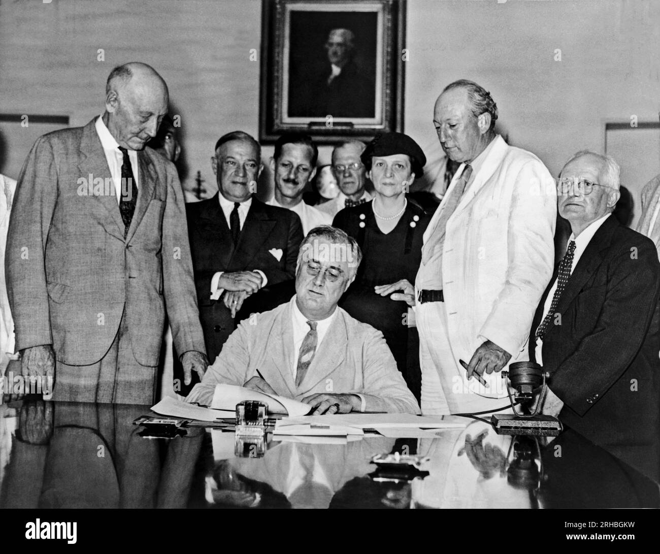 Washington, D.C.: 1935 Präsident Franklin D. Roosevelt unterzeichnet Sozialversicherungsgesetz. Hinter Roosevelt stehen von links nach rechts: Rep. Robert Doughton, Senator Robert Wagner, Arbeitsminister Frances Perkins, Senator Pat Harrison, Rep. David J. Lew Stockfoto