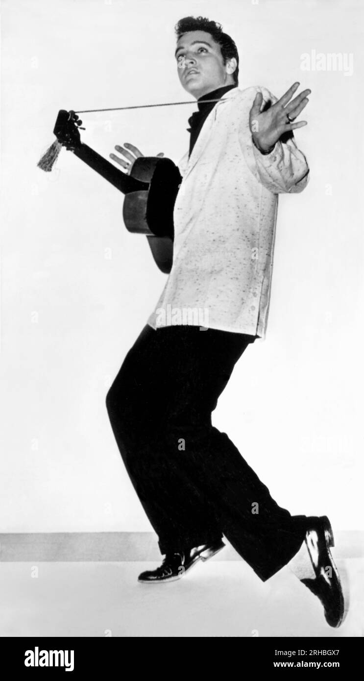 Hollywood, Kalifornien: 10. April 1956 das neue „bobby sox“-Idol Elvis Presley, der 21 Jahre alte Ex-Lkw-Fahrer von Memphis, der eine wilde Gitarre spielt und sich mit seinen Blues-Liedern in einen Rausch stürzt, hat einen langfristigen Filmvertrag mit Hal Wallis unterzeichnet. Stockfoto Hollywood, Kalifornien: 10. April 1956 das neue „bobby sox“-Idol Elvis Presley, der 21 Jahre alte Ex-Lkw-Fahrer von Memphis, der eine wilde Gitarre spielt und sich mit seinen Blues-Liedern in einen Rausch stürzt, hat einen langfristigen Filmvertrag mit Hal Wallis unterzeichnet. Stockfoto