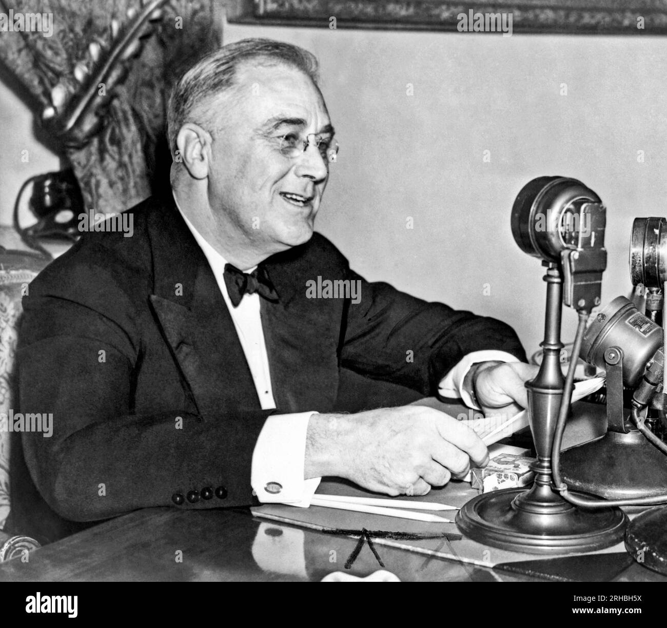 Washington, D.C.: 1937. Präsident Franklin D. Roosevelt, sitzt hinter dem Mikrofon, während eines seiner Kamingespräche. Stockfoto