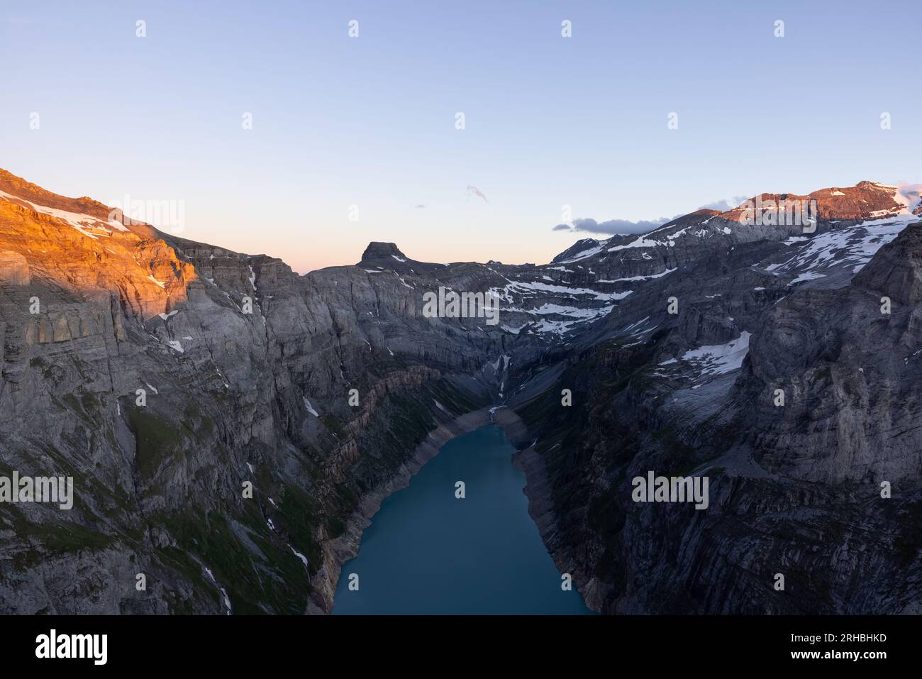 Epischer Sonnenuntergang über einem alpinen See namens Limmerensee in der Schweiz. Wundervolle Landschaft in den alpen. Die Sonne scheint zu den Gipfeln der Berge. Stockfoto