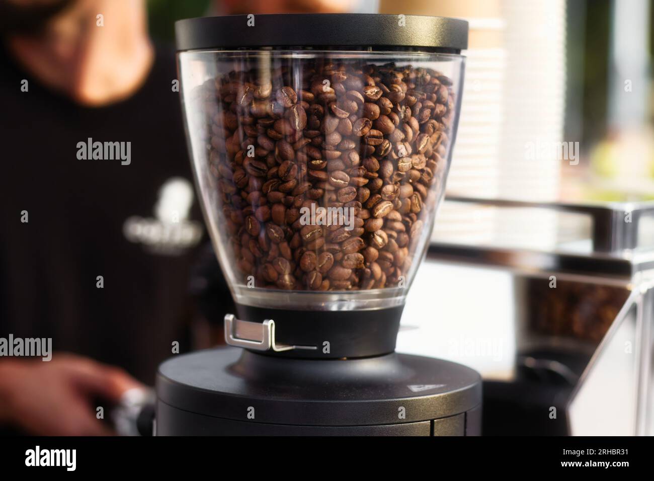 Viele echte, ganze Kaffeebohnen in einer professionellen Brühmaschine mit automatischer Mühle oben Stockfoto