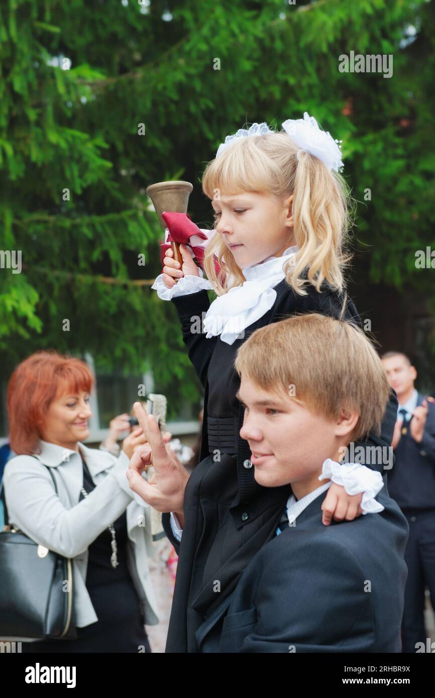 Kolomna, Region Moskau, Russland. 01. September 2014 traditionelle Schule erste und letzte Glocke. Ein Schüler trägt einen Erstklässler mit einer Glocke auf der Schulter Stockfoto