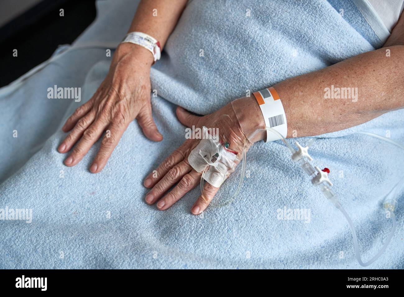 Von oben anonyme ungesunde Patientin mit angeschlossenem Venenkatheter auf der Liege während des Rehabilitationsprozesses im Krankenhaus Stockfoto