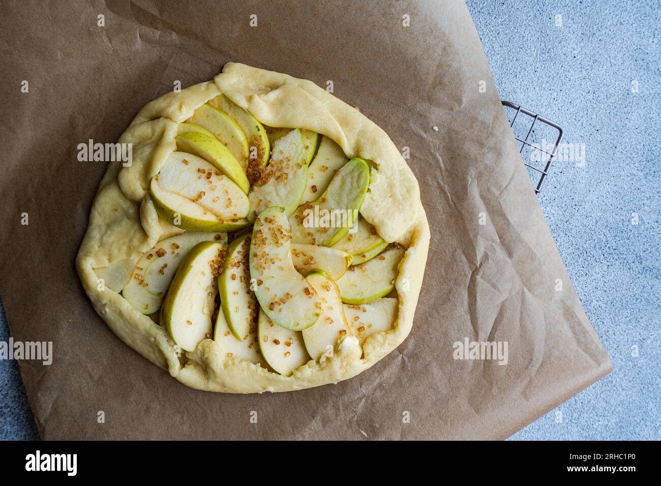 Blick über eine rohe hausgemachte Apfelgalette auf Pergamentpapier Stockfoto