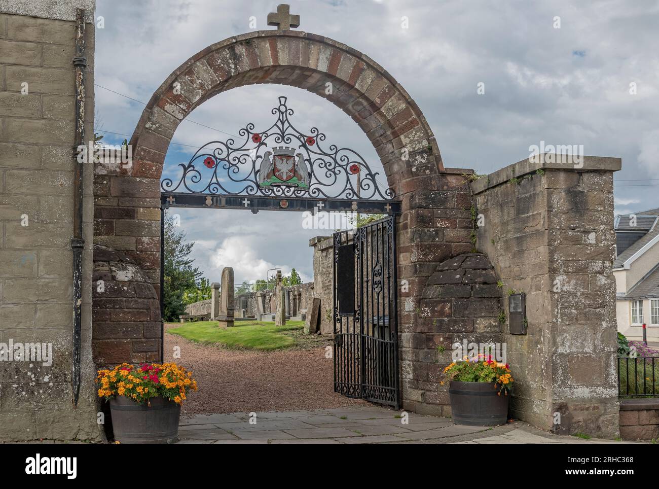 Auchterarder, Schottland, Großbritannien - 13. August 2023 - Bogeneingang zu einem Kirchhof mit Metalltor und Wappen Stockfoto