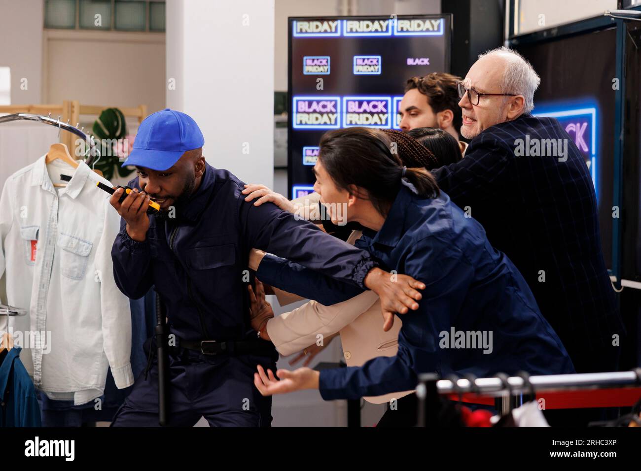 Der Sicherheitsdienst nutzt Walkie-Talkie, um die Menge der wütenden, aggressiven Menschen zu bewältigen, die während des Black Friday versuchen, in das Einkaufszentrum einzubrechen. Verrückte ängstliche Käufer, die in den Laden einbrechen, um Dinge zu kaufen, die im Angebot sind Stockfoto