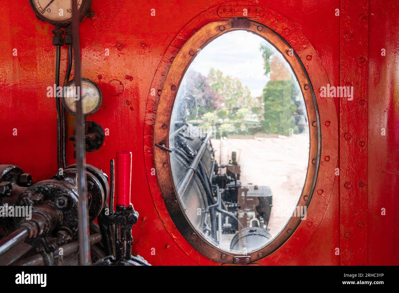 Blick vom Fenster auf das rot lackierte Fahrerhaus einer alten Dampflokomotive Stockfoto