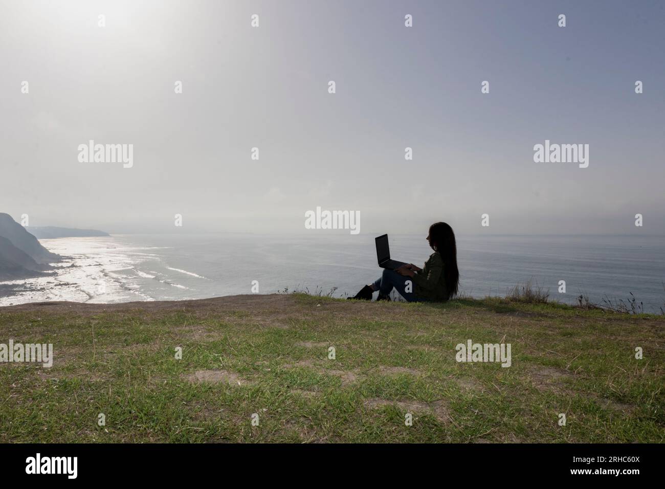 Stilvolle Frau, die eine Videokonferenz vor dem Hintergrund des Ozeans durchführt Stockfoto