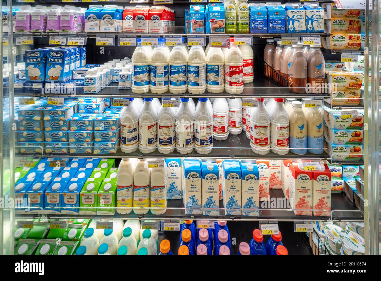 Italien - 14. August 2023: Packungen mit frischer Milch und frischer Sahne verschiedener Sorten und Marken auf der Arbeitsfläche zum Verkauf im italienischen Supermarkt Stockfoto