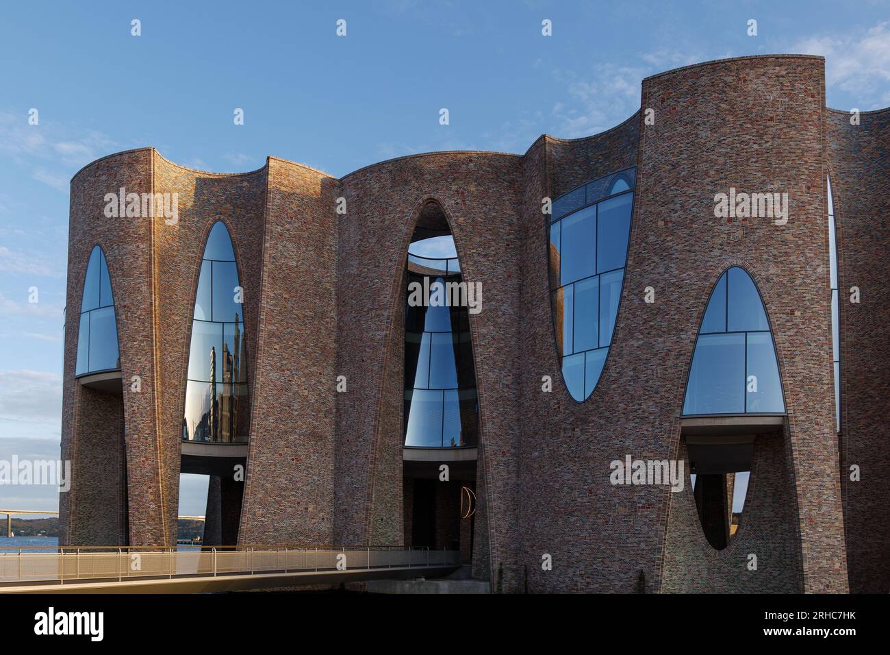Vejle, Dänemark - 06. OKTOBER 2022: Außenansicht und Details der gebogenen Ziegelwand und Fenster am Fjordenhus während des Sonnenuntergangs. Stockfoto