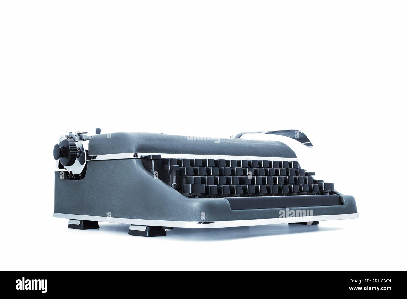 Alte mechanische Schreibmaschine im Vintage-Stil aus Metall, mit schwarzen Tasten und einem speziellen Hebel für den Wagenrücklauf. Auf einem weißen Hintergrund, angezeigt von Stockfoto