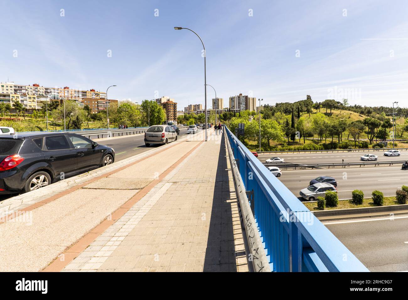 Über eine Brücke mit einem normalen Bürgersteig und einer Radspur auf einer Autobahn mit Fahrzeugverkehr zu laufen Stockfoto