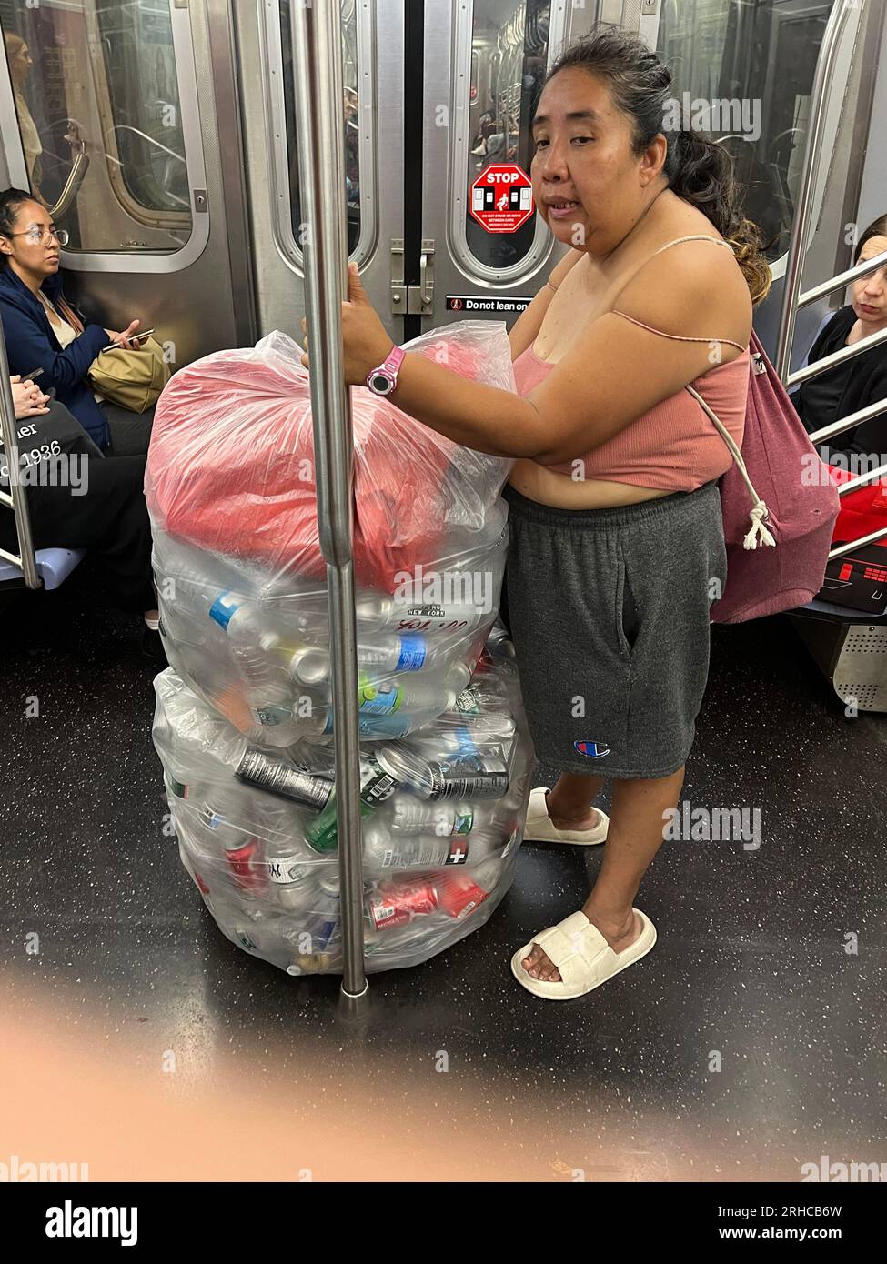 Eine arme Immigrantin, die Limonadendosen gesammelt hat, fährt mit der U-Bahn in Brooklyn, New York. Stockfoto