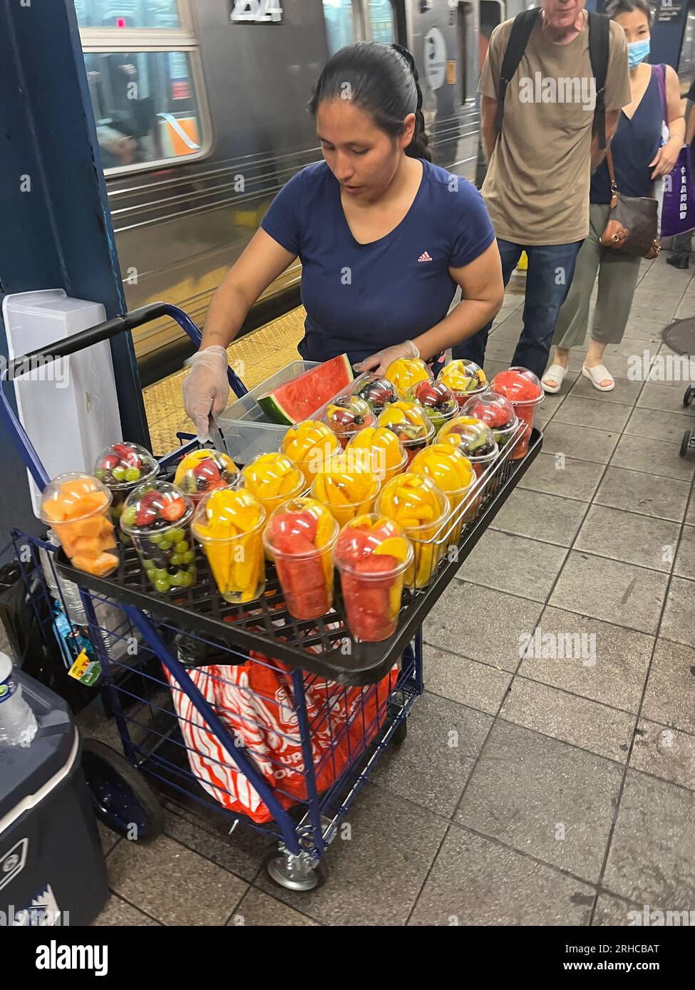 Hispanic Woman verkauft frische Obstbecher auf der U-Bahn-Station Broadway/Lafayette in Manhattan, New York City. Stockfoto