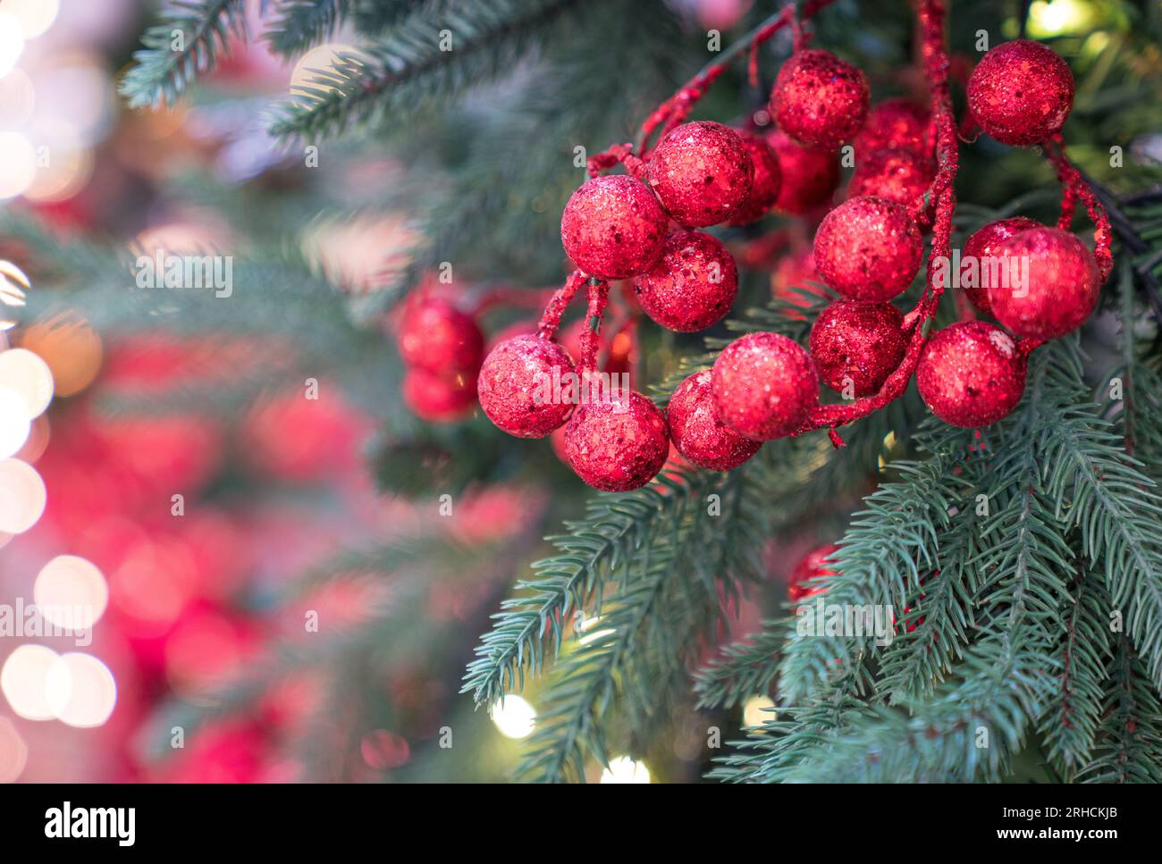 Weihnachtsdekorationen hängen auf dem Baum, mit Bokeh-Hintergrund. Stockfoto