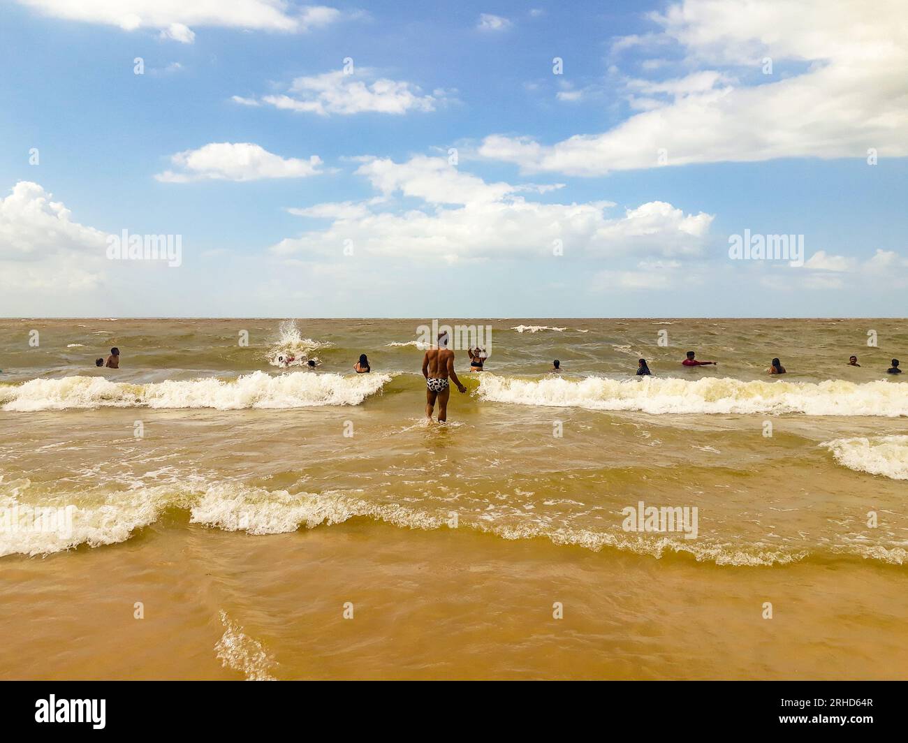 Einige Leute haben Spaß in den Wellen am Strand Olho D'água in São Luís, Maranhão, Brasilien. Stockfoto