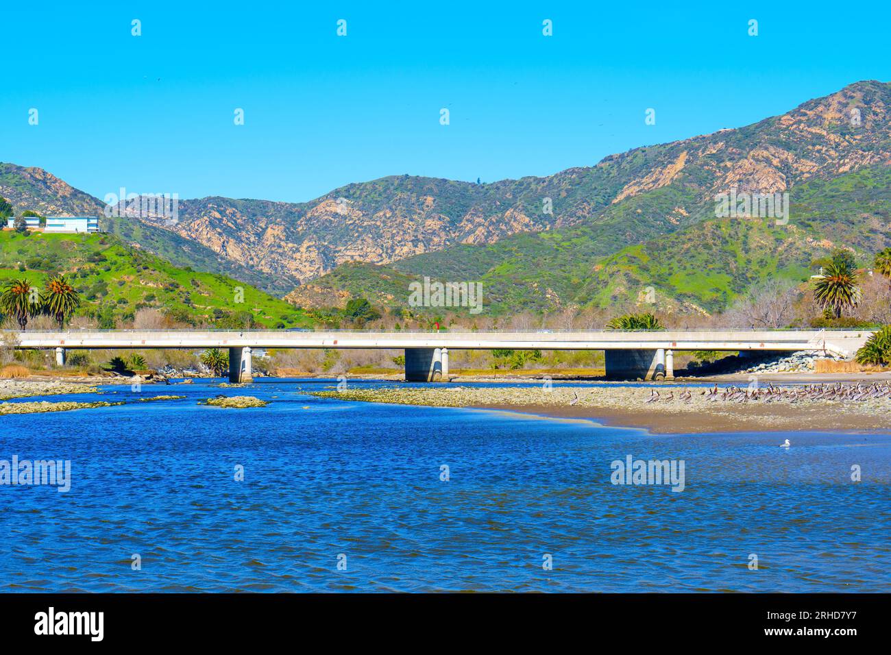 Blick auf den Abschnitt Pacific Coast Highway von der Malibu Lagune aus von einem niedrigen Aussichtspunkt vor einem malerischen Berghintergrund. Stockfoto