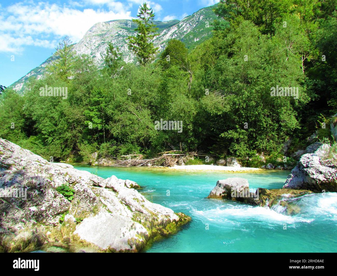 Emerald gefärbter Soca-Fluss im Trenta-Tal, Slowenien und Berge risig darüber Stockfoto