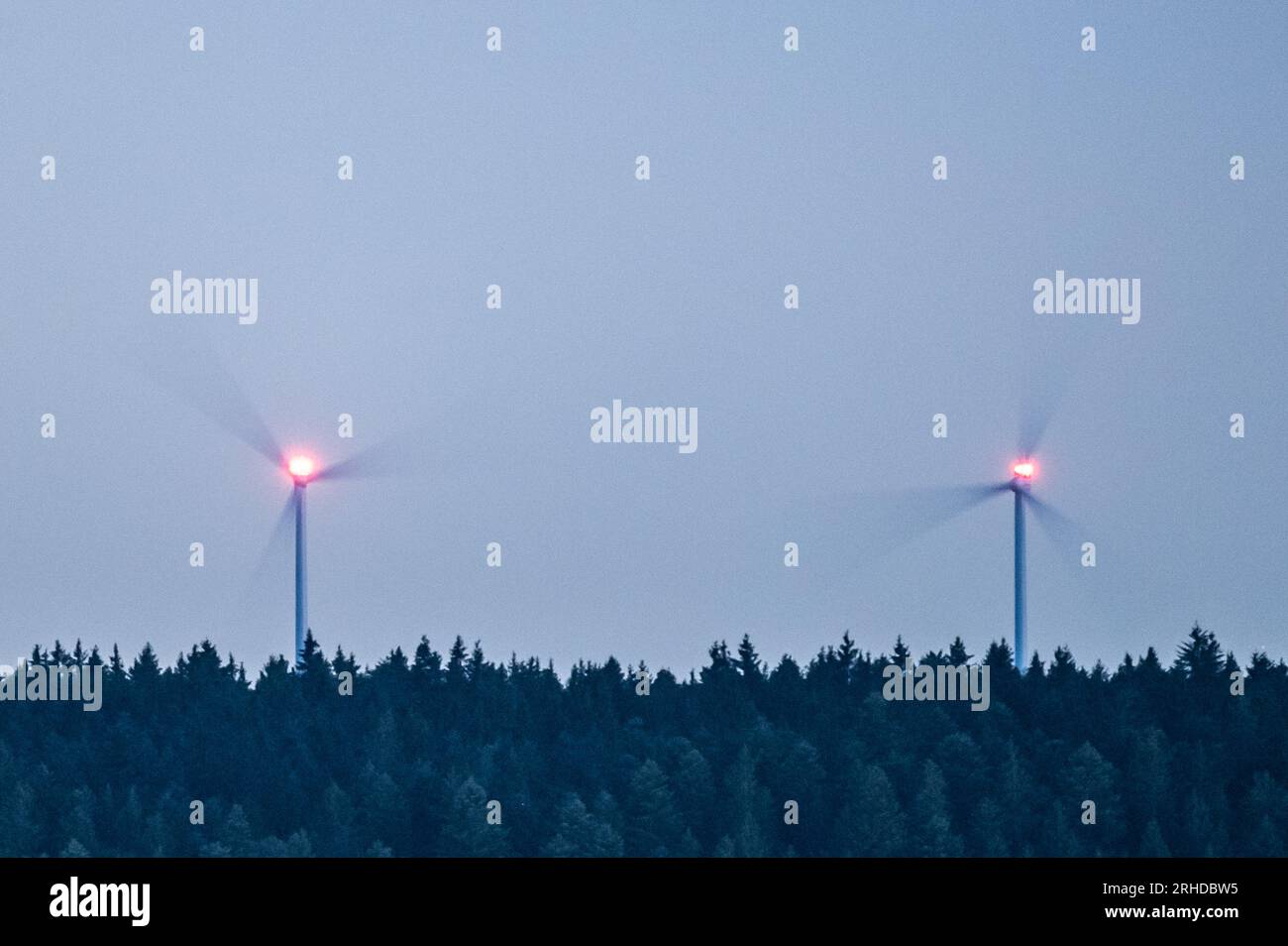Spaichingen, Deutschland. 15. Aug. 2023. Windturbinen drehen sich im Dunkeln in einem bewaldeten Bereich. Kredit: Silas Stein/dpa/Alamy Live News Stockfoto