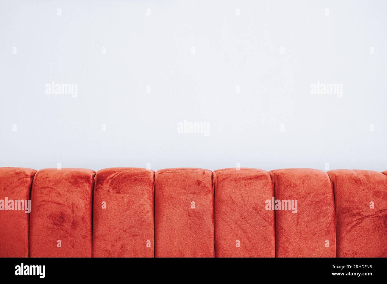 Nahaufnahme rotes Sofa vor weißer Wand als Hintergrund Stockfoto
