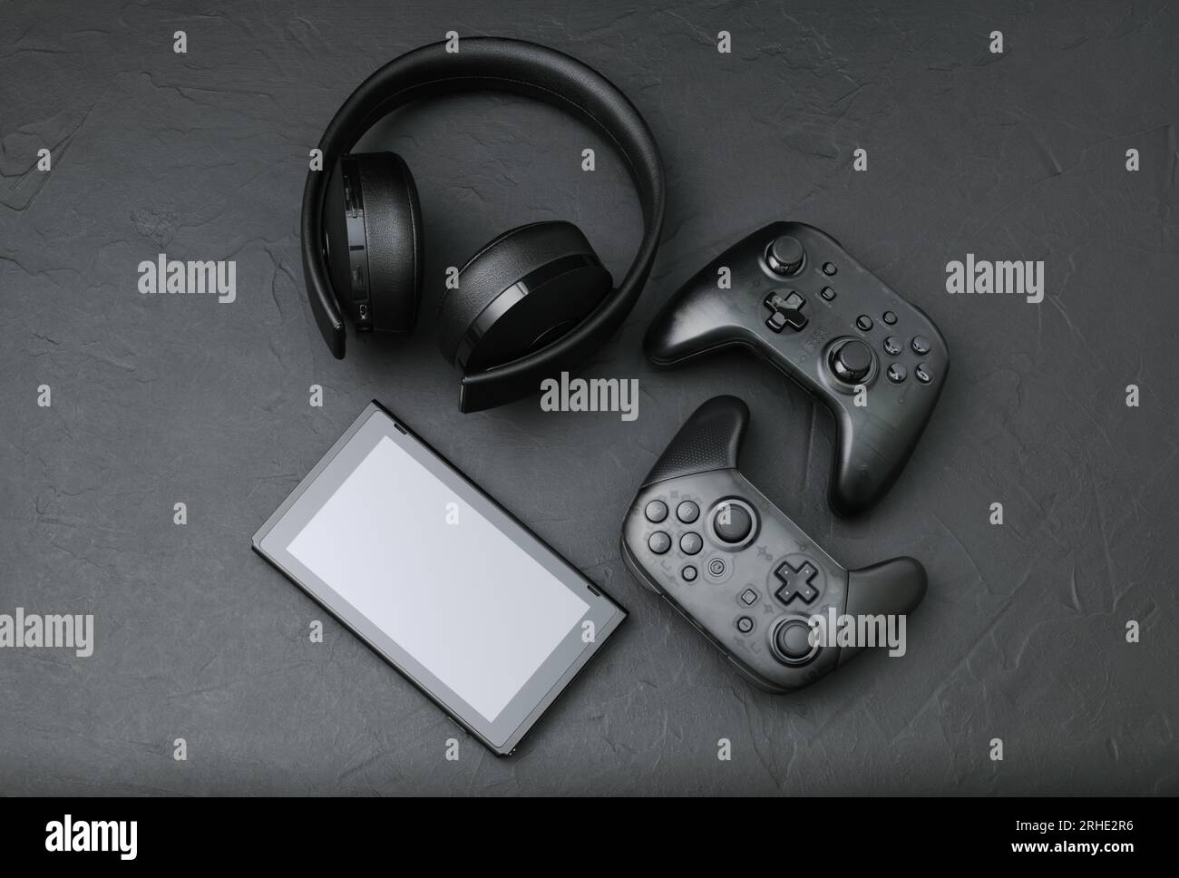Schwarze Geräte: Gamepads, Headset und Tablet-pc. Gaming-Konzept auf schwarzem Hintergrund Stockfoto
