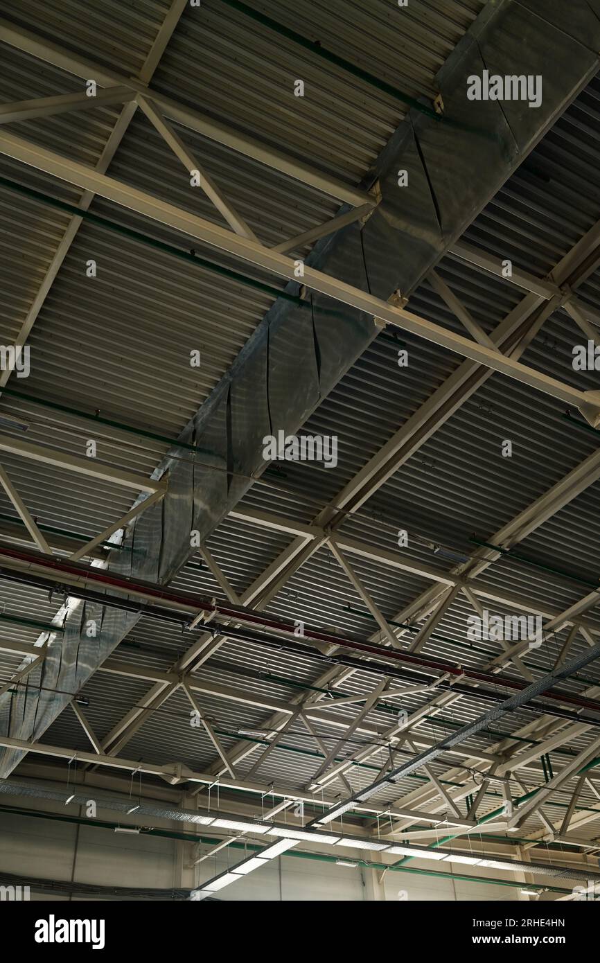 Teil der Decke eines geräumigen Lagers oder Lagerraums einer modernen Industrieanlage oder Fabrik, dargestellt durch graue Metallstrukturen Stockfoto