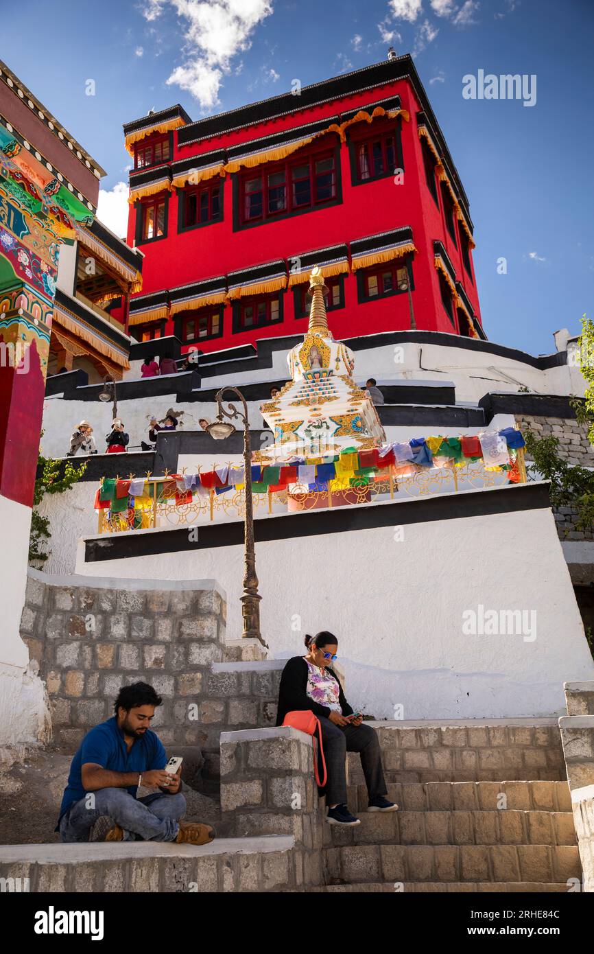 Indien, Ladakh, Leh Valley, Thiksey Gompa, buddhistisches Kloster der Gelug-Schule, die sich unter der Montagehalle und den Chorten ausruhen und Telefone anschauen Stockfoto