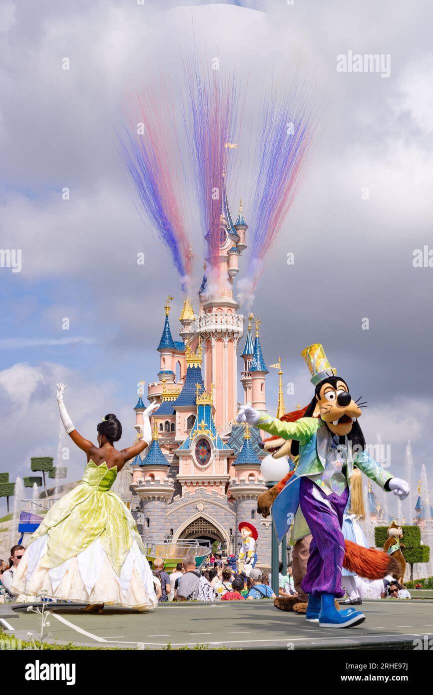 Disneyland Paris Parade und Charaktere tanzen vor dem Disneyland Castle Feuerwerk, mit Goofy und Prinzessin Tiana; Disney Paris Frankreich Stockfoto