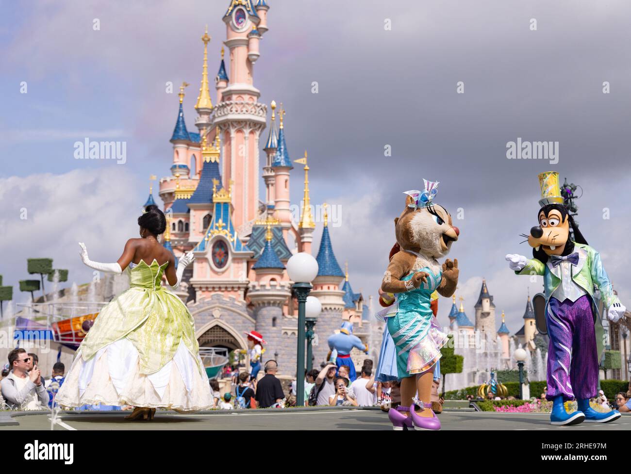 Disneyland Paris; Disney-Figuren vor dem Disneyland Castle tanzen während der Disneyland Parade; Prinzessin Tiana, Clarice und Goofy; Frankreich Stockfoto