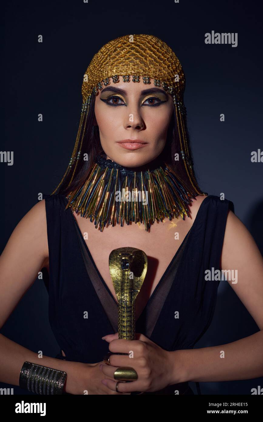 Porträt einer Frau im ägyptischen Look und Kopfschmuck mit einem Schlangenbund auf blauem Hintergrund Stockfoto